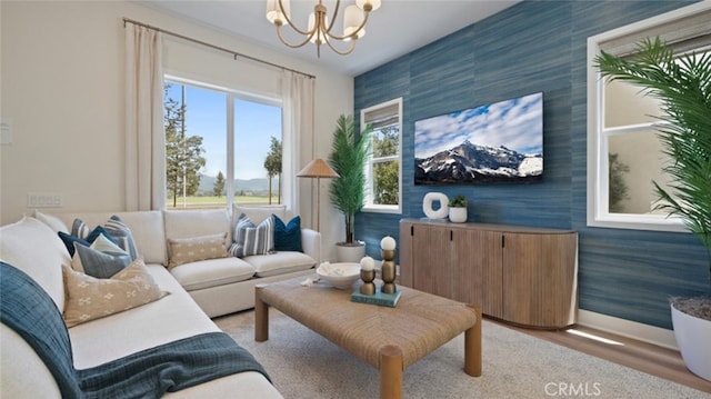 living room with an inviting chandelier, an accent wall, and wallpapered walls