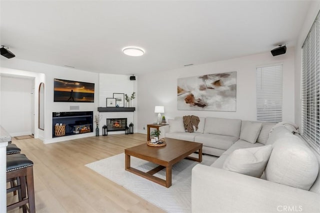 4355 Leonard Way, Corona, CA 92883 - living area with a glass covered fireplace, light wood-style flooring, and baseboards