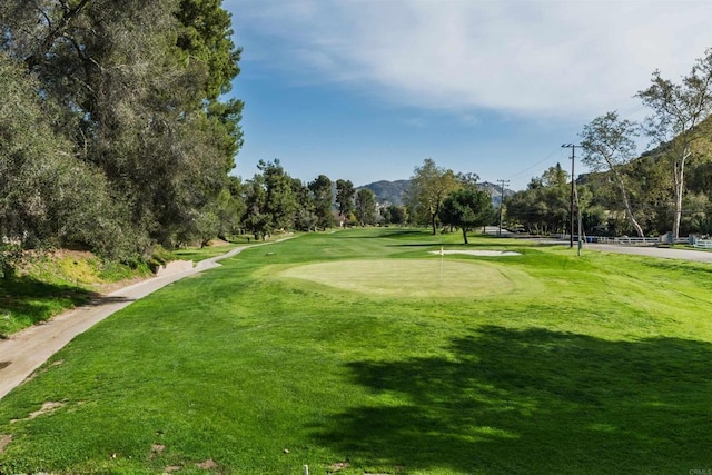view of home's community featuring a lawn and golf course view