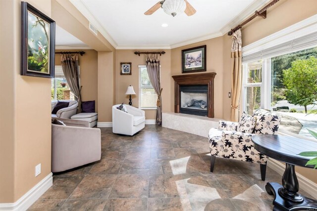 living area with plenty of natural light, crown molding, and a glass covered fireplace