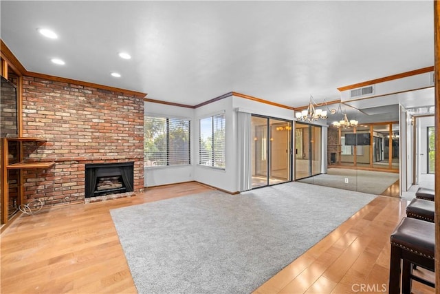 7201 Apricot Dr Unit 7201, Irvine, CA 92618 - unfurnished living room with a chandelier, a fireplace, wood finished floors, healthy amount of natural light, and ornamental molding