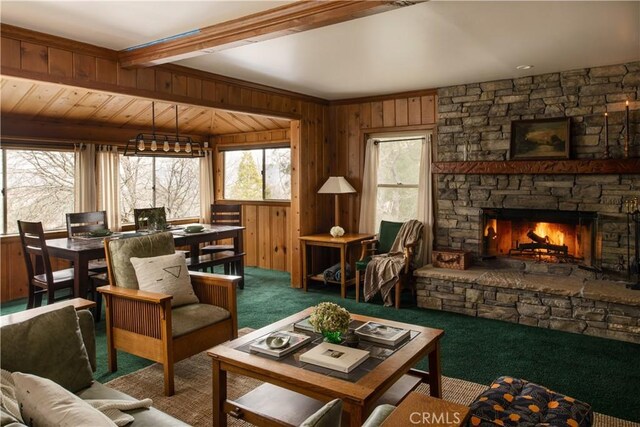 29196 Lake Brook Ave, Cedar Glen, CA 92321 - living room with carpet floors, wooden walls, a stone fireplace, and beam ceiling