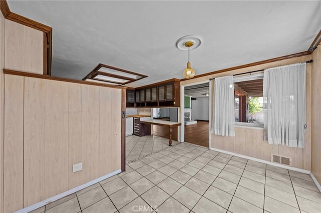 579 E 40th St, San Bernardino, CA 92404 - kitchen with baseboards, light tile patterned floors, and wood walls