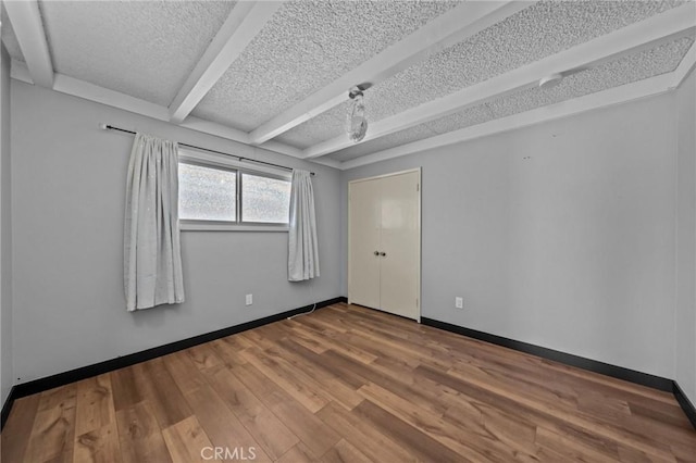579 E 40th St, San Bernardino, CA 92404 - empty room with wood finished floors, baseboards, a textured ceiling, and beamed ceiling