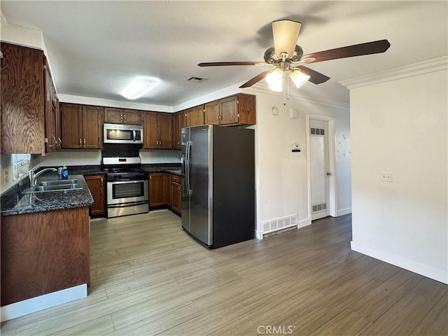 2414 Grove Ave, San Diego, CA 92154 - kitchen with stainless steel appliances, a sink, a ceiling fan, light wood-style flooring, and baseboards