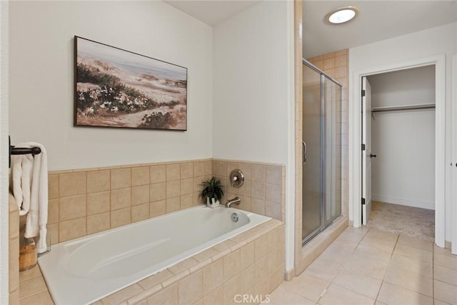 bathroom with a garden tub, a stall shower, a spacious closet, and tile patterned flooring