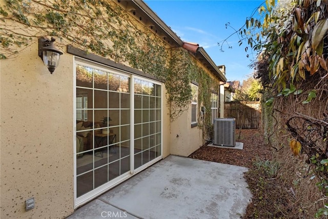 view of patio with central AC unit and fence