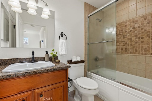 full bathroom with vanity, toilet, and bath / shower combo with glass door