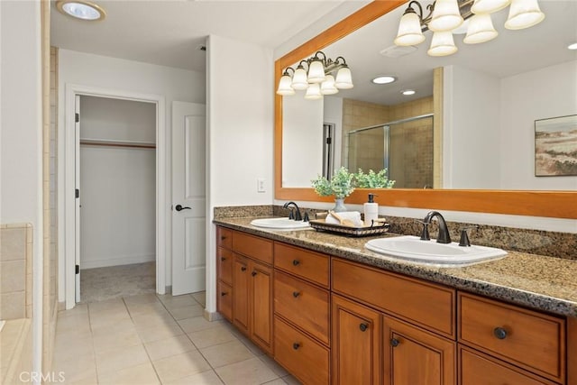 bathroom with tile patterned flooring, a stall shower, double vanity, and a sink