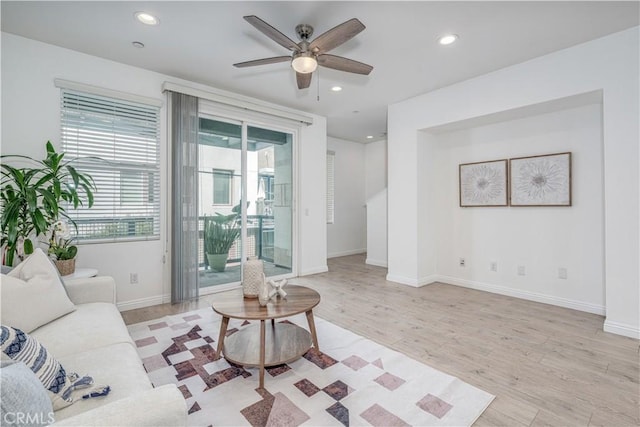 living room featuring light wood-style flooring, recessed lighting, a ceiling fan, and baseboards