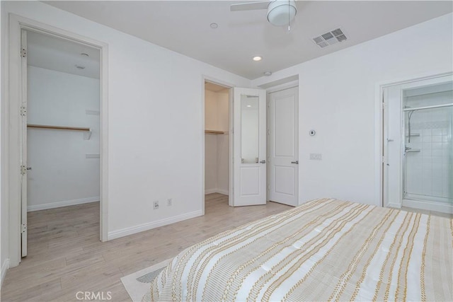 bedroom with a spacious closet, a closet, light wood finished floors, baseboards, and recessed lighting