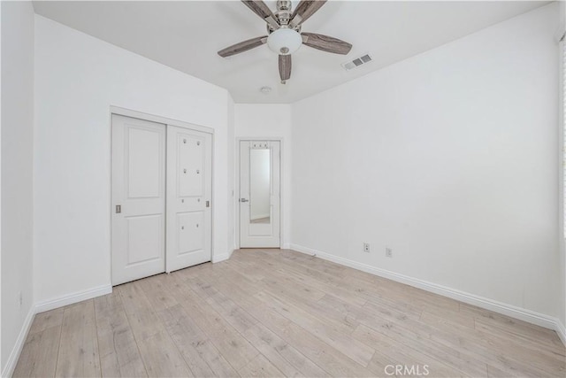 unfurnished bedroom with light wood-style flooring, baseboards, ceiling fan, and a closet