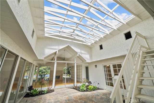 view of patio / terrace featuring stairs and a lanai