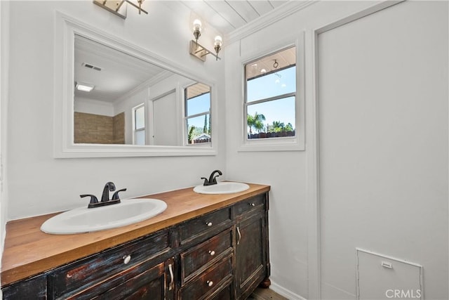 full bath featuring a sink, ornamental molding, and visible vents