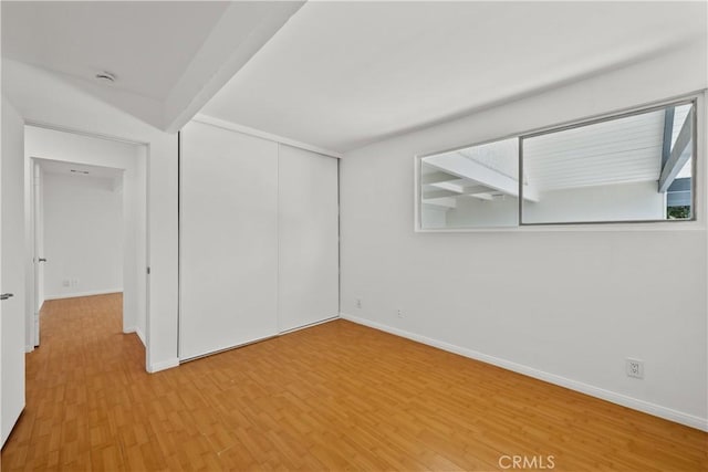 empty room with light wood-style flooring and baseboards