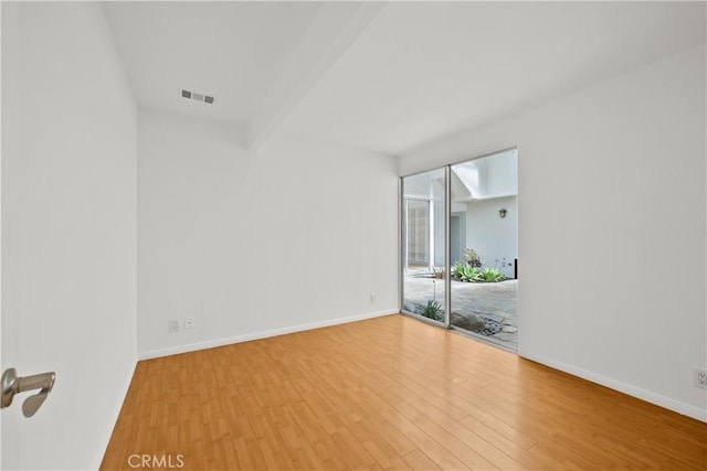 unfurnished room featuring visible vents, baseboards, beamed ceiling, and wood finished floors