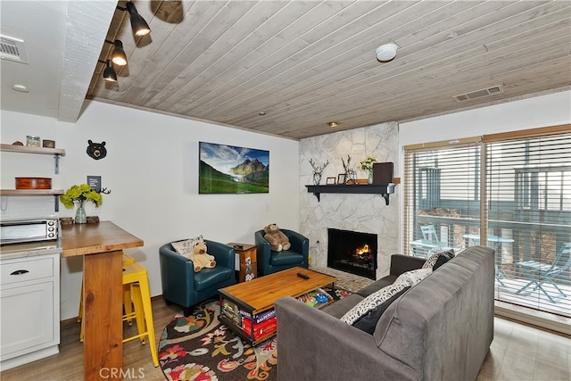 39802 Lakeview Dr Unit 26, Big Bear Lake, CA 92315 - living area featuring a stone fireplace, visible vents, light wood-style floors, and wood ceiling
