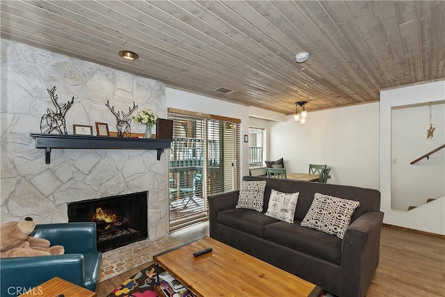 39802 Lakeview Dr Unit 26, Big Bear Lake, CA 92315 - living area featuring a stone fireplace, wooden ceiling, wood finished floors, and visible vents