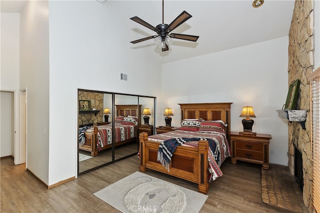 39802 Lakeview Dr Unit 26, Big Bear Lake, CA 92315 - bedroom with a stone fireplace, a high ceiling, wood finished floors, and visible vents