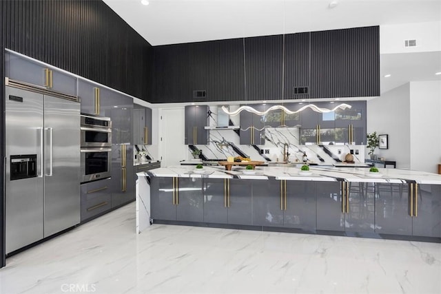 18802 Saginaw Dr, Irvine, CA 92603 - kitchen with stainless steel appliances, a high ceiling, light marble finish flooring, light stone countertops, and modern cabinets