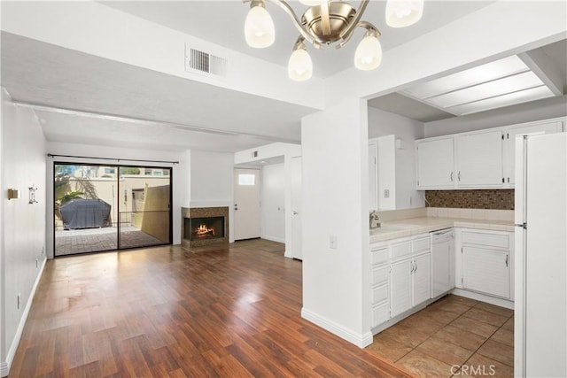 25712 Le Parc Unit 21, Lake Forest, CA 92630 - kitchen with white appliances, white cabinets, open floor plan, wood finished floors, and a warm lit fireplace