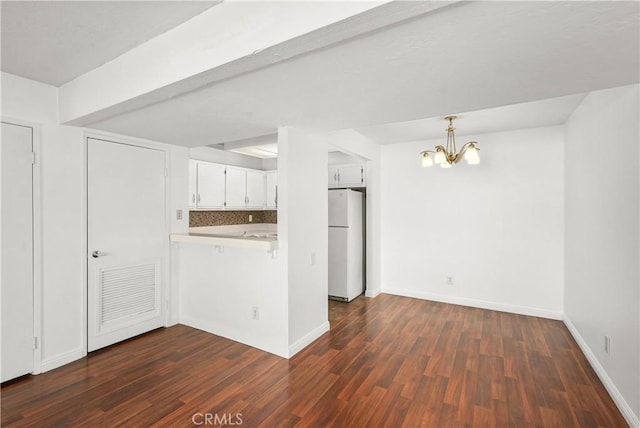 25712 Le Parc Unit 21, Lake Forest, CA 92630 - kitchen with freestanding refrigerator, a chandelier, dark wood-type flooring, a peninsula, and white cabinets