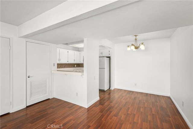 25712 Le Parc Unit 21, Lake Forest, CA 92630 - kitchen featuring freestanding refrigerator, a chandelier, dark wood-style flooring, a peninsula, and white cabinetry