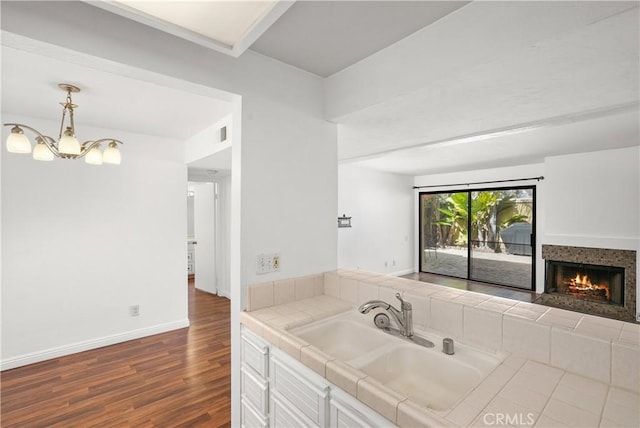 25712 Le Parc Unit 21, Lake Forest, CA 92630 - kitchen with a sink, tile counters, a tile fireplace, dark wood finished floors, and open floor plan