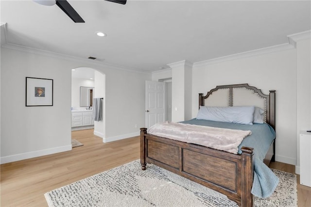 bedroom featuring baseboards, light wood-type flooring, arched walkways, and ornamental molding