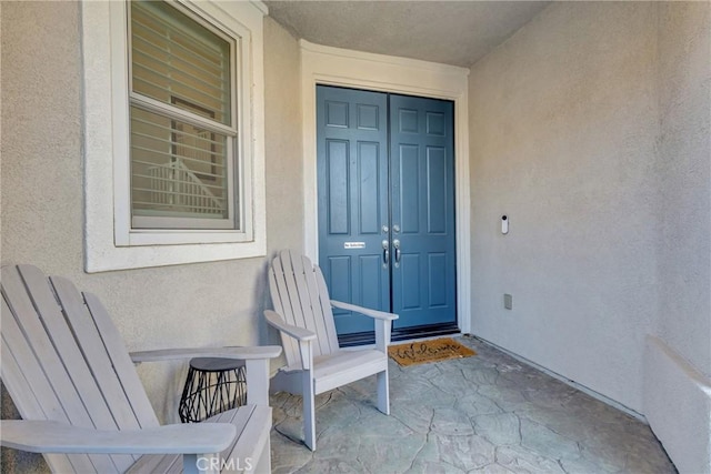 entrance to property featuring stucco siding