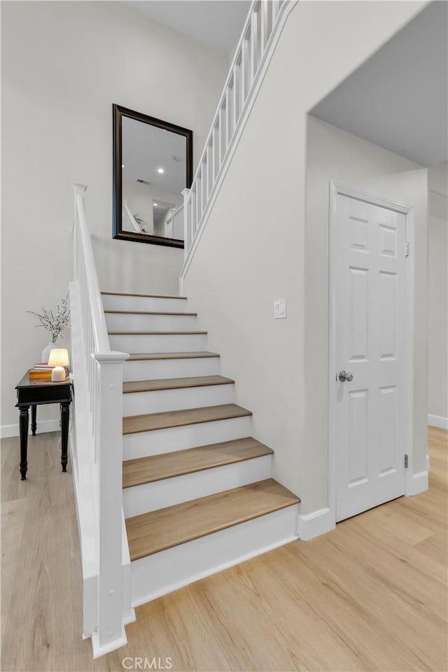 staircase with baseboards and wood finished floors