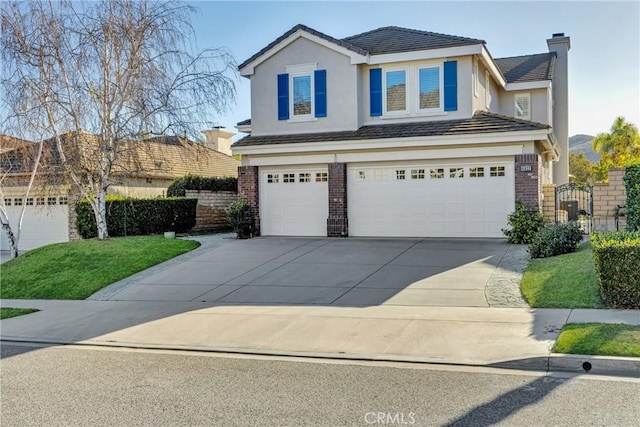 view of front of house featuring concrete driveway, a chimney, stucco siding, an attached garage, and brick siding