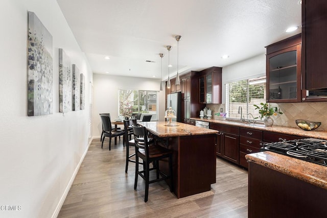 12084 London Grove Ct, Moorpark, CA 93021 - kitchen featuring appliances with stainless steel finishes, a sink, a kitchen breakfast bar, a center island, and backsplash