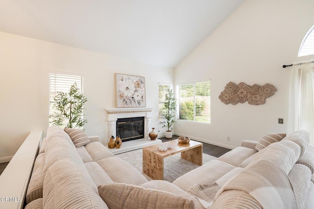 12084 London Grove Ct, Moorpark, CA 93021 - living area with wood finished floors, high vaulted ceiling, baseboards, and a glass covered fireplace