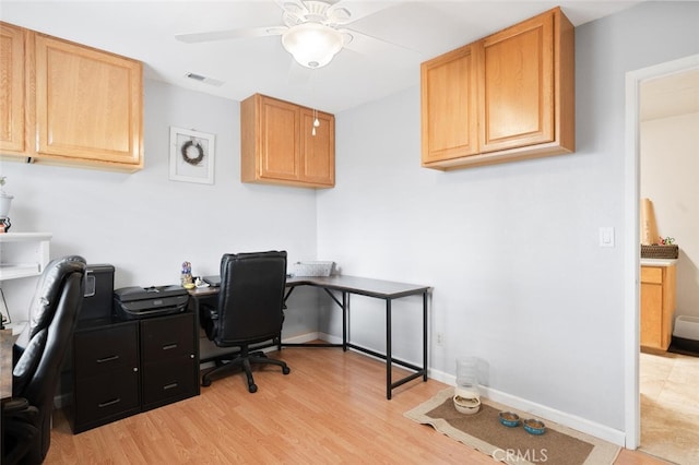 office featuring light wood-style flooring, baseboards, ceiling fan, and visible vents