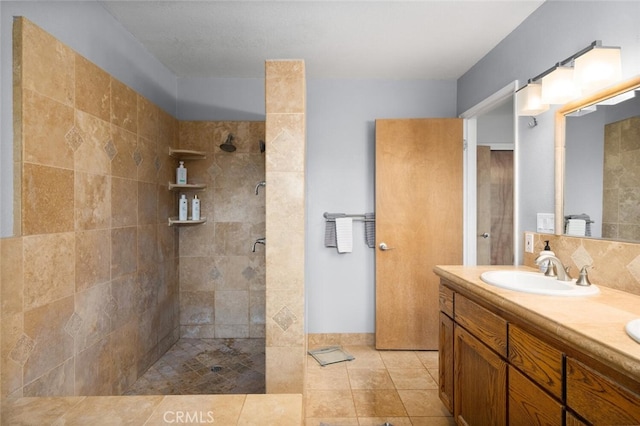 full bath with double vanity, a sink, and a tile shower