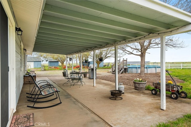 view of patio / terrace featuring grilling area, an outdoor pool, fence, and outdoor dining space