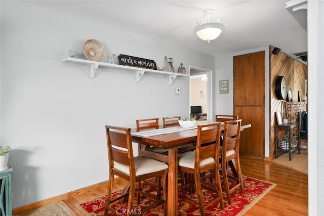 dining space featuring baseboards and light wood-style floors