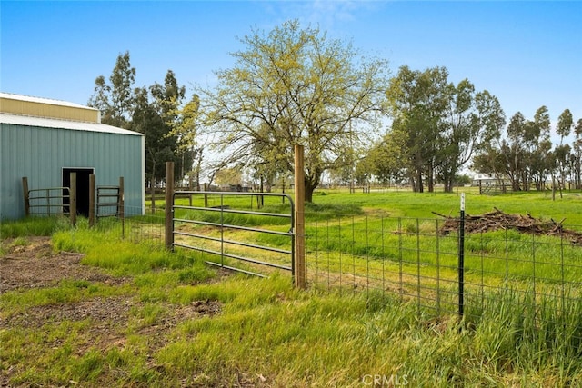 exterior space with a pole building, an outbuilding, and fence