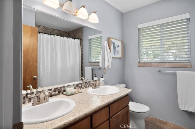 bathroom featuring plenty of natural light, toilet, and a sink