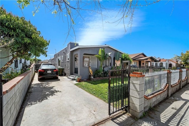 730 E 89th St, Los Angeles, CA 90002 - view of front of house featuring a fenced front yard, a residential view, concrete driveway, a front yard, and stucco siding