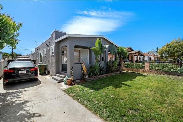 730 E 89th St, Los Angeles, CA 90002 - view of front of house featuring a front yard, fence, and stucco siding
