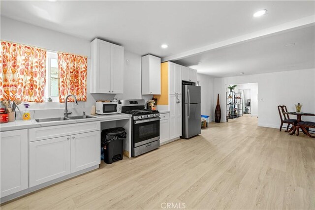 730 E 89th St, Los Angeles, CA 90002 - kitchen featuring light wood finished floors, a sink, recessed lighting, stainless steel appliances, and light countertops