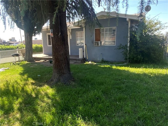exterior space with a patio, stucco siding, fence, and a lawn