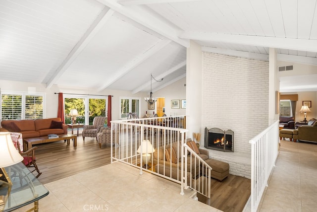 living room with beamed ceiling, plenty of natural light, a fireplace, and visible vents
