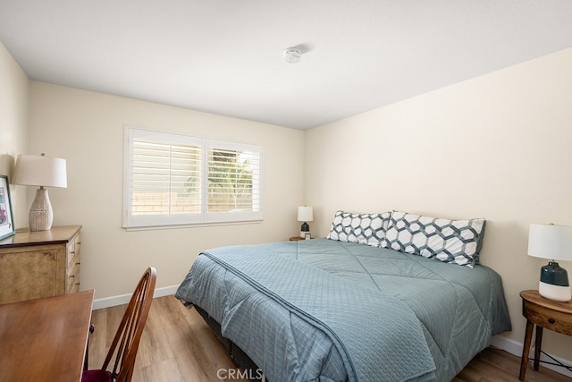 bedroom featuring baseboards and wood finished floors