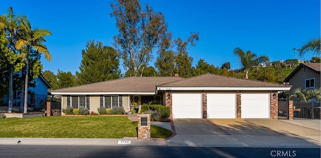 ranch-style home featuring brick siding, fence, a front lawn, concrete driveway, and an attached garage