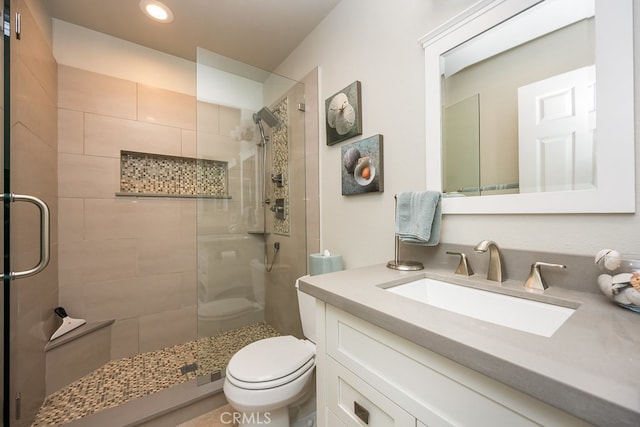 bathroom featuring vanity, recessed lighting, a stall shower, and toilet