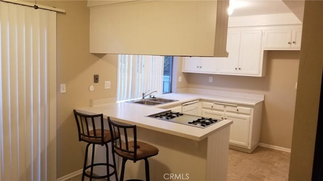 414 Nobel Ave Unit D, Santa Ana, CA 92707 - kitchen featuring white gas stovetop, a sink, white cabinets, and a peninsula