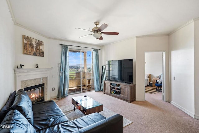 living area with carpet flooring, baseboards, crown molding, and ceiling fan